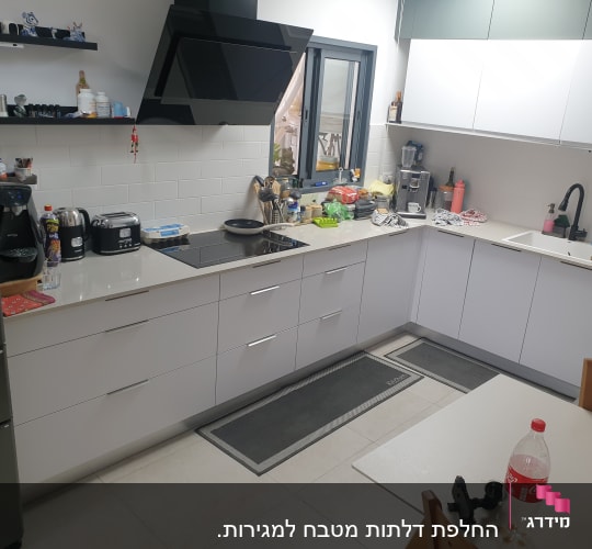 מטבח מודרני עם מכשירי חשמל וכלי בישול על השיש
